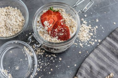 Bir bardak çikolata topları, yulaf ezmesi ve meyve ile lezzetli beyaz yoğurt