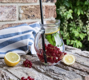 Ev yapımı ferahlatıcı limonata, buz ve limon ile kırmızı kuş üzümü