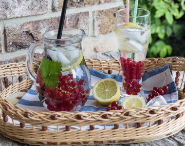 Ev yapımı ferahlatıcı limonata, buz ve limon ile kırmızı kuş üzümü