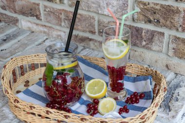 Ev yapımı ferahlatıcı limonata, buz ve limon ile kırmızı kuş üzümü