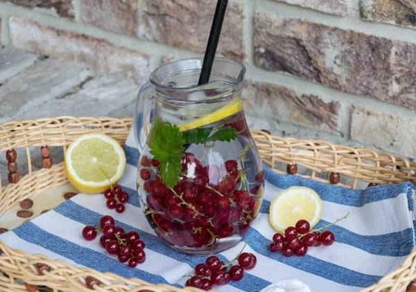 Ev yapımı ferahlatıcı limonata, buz ve limon ile kırmızı kuş üzümü