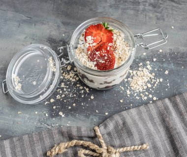 Bir bardak çikolata topları, yulaf ezmesi ve meyve ile lezzetli beyaz yoğurt