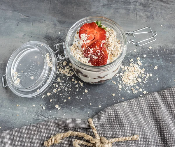 Bir bardak çikolata topları, yulaf ezmesi ve meyve ile lezzetli beyaz yoğurt