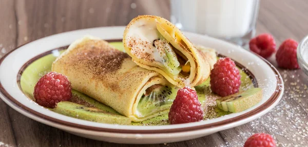 Homemade pancake with curd, raspberries, kiwi and banana pieces sprinkled with cocoa — Stock Photo, Image