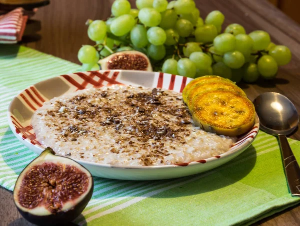 Köstliche Haferflocken mit Schokolade und Fruchtstücken aus Feigen, Bananen, Trauben und Kakteenfeigen — Stockfoto