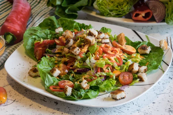 Свежий овощной салат с хрустящими гренками и французскими соусами — стоковое фото