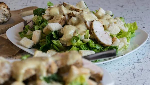 Mükemmel Sezar salatası kavrulmuş pasta ve tavuk parmesan peyniri ile serpilir,