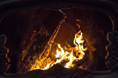 Ev ocağı. Şöminede yangın var. Noel havası. Işığın enerjisi. Ateşin sıcaklığının tadını çıkartın. Yanan kütük. Şenlik ateşi. Odun ve kömür yakın..