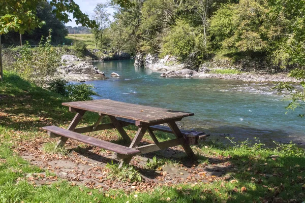 Table and bench in nature. Rest in the forest. Halt during a hiking trip. Lunch by the river. Outdoor picnic. Camino de Santiago. The way of the pilgrim. Camino Frances.