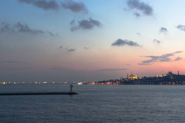 Deniz limanı. Boğaz Boğazı. İstanbul manzarası. Sahil tatil köyü. Suyun üstünde feribot. Denizde bir gemi. Gün batımı gökyüzü. Gökyüzü gradyanı. İstanbul 'da deniz manzarası. Şehir ufukta görünüyor. Pembe ve mavi gölgeler.
