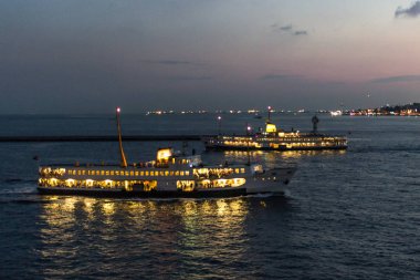 Deniz limanı. Boğaz Boğazı. İstanbul manzarası. Sahil tatil köyü. Suyun üstünde feribot. Denizde bir gemi. Gün batımı gökyüzü. Gökyüzü gradyanı. İstanbul 'da deniz manzarası. Şehir ufukta görünüyor. Pembe ve mavi gölgeler.