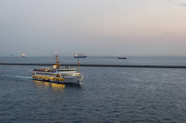Deniz limanı. Boğaz Boğazı. İstanbul manzarası. Sahil tatil köyü. Suyun üstünde feribot. Denizde bir gemi. Gün batımı gökyüzü. Gökyüzü gradyanı. İstanbul 'da deniz manzarası. Şehir ufukta görünüyor. Pembe ve mavi gölgeler.