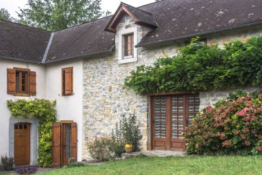 Özel bir ev. Köy köşkü. Eski bina. Evin girişi kapalıydı. Fransız köyü. Taş cephe. Ortaçağ mimarisi. Kır evi. Taş duvar. Bahçede peyzaj..