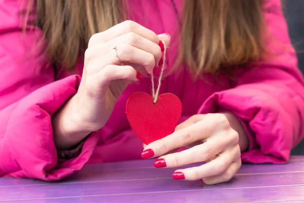 Romantic girl. Symbol of love. Red heart in the hands. St. Valentine\'s Day. Romantic date. Engagement ring. Woman in love. Tender feelings. Pink glasses.