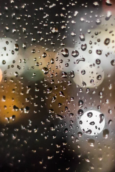 Spring rain. May thunderstorm. Raindrops on the glass. The texture of the drops. Wet window. Chill day. Inclement weather. Torrential rain. View of the world from the window.