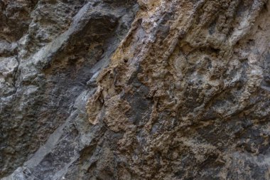 Kayanın bir parçası. Taş zemin. Taşın dokusu. Kaya oluşumu. Katı malzeme. Granit duvar. Tasarımda doğal malzemeler. Sert yüzey.