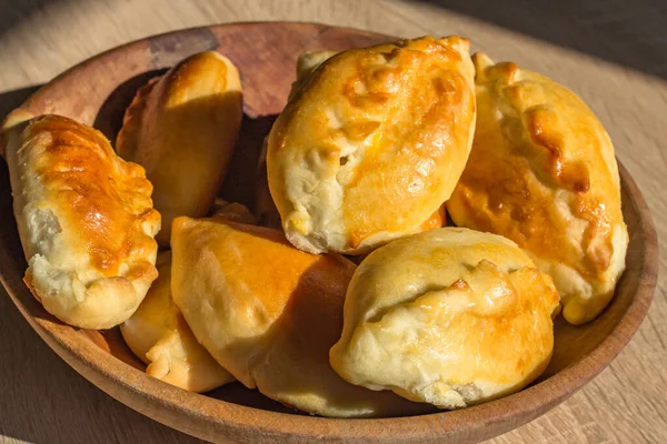 Fırında kek. Maya pişirme. Etli turtalar, lahana ve mantarlı. Ev yapımı yemek. Slav mutfağı. Lezzetli hamur işleri. Lanet atıştırmalıklar. Un ürünü. Fırında pişir. Abur cubur. Basit bir köy yemeği. Ukrayna ulusal mutfağı. Güzel kokulu hamur işleri.