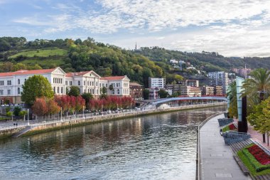 Bilbao 'daki Nervion Nehri' nin kıyısında. Nehrin kıvrımları. Şehirdeki sonbahar renkleri. İspanya 'da seyahat. Avrupa şehri. Nehir kenarındaki renkli şehir manzarası. Bask Ülkesi. İspanya 'nın büyük şehri.