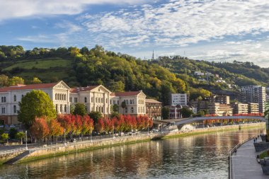 Bilbao 'daki Nervion Nehri' nin kıyısında. Nehrin kıvrımları. Şehirdeki sonbahar renkleri. İspanya 'da seyahat. Avrupa şehri. Nehir kenarındaki renkli şehir manzarası. Bask Ülkesi. İspanya 'nın büyük şehri.