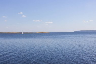 Nehirde ada ve yat. Dinyeper 'da yelkenli bir tekne. Ukrayna 'nın doğası. Resimli bir manzara. Güzel göl manzarası. Baharda kamp yapmak. Suda küçük dalgalanmalar. Rahatlık adacığı.
