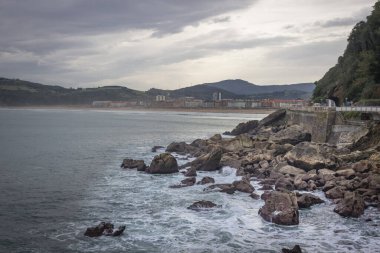 Deba tatil köyünün geniş plajı. İspanya 'da tatiller. Sörfçülere yer açın. Bilinmeyen sörfçüler. Suda son derece eğlenceli. Su sporu. Yavaşça eğimli kıyı.