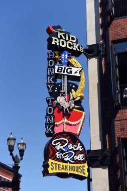 Nashville, TN, USA - September 21, 2019:  Kid Rock's Big Ass Honky Tonk Rock N' Roll Steakhouse on the busy Broadway Street which opened in 2019. The sign caused controversy because the base of the instrument is intentionally shaped like a woman's bu