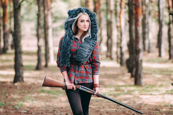 Mulher bonita caçadora na floresta com arma — Fotografia de Stock