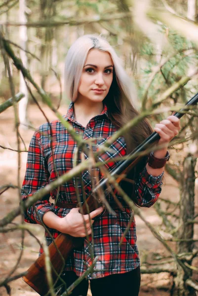 Hermosa mujer cazadora en el bosque con pistola Imagen de archivo