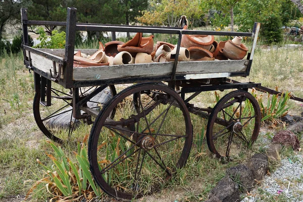 Old and abandoned wooden traditional cart with traditional turkish cooking clay pots