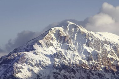Karlı ve bulutlu dağ zirvesi