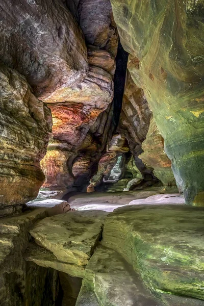 In Hocking Hills State Park, Ohio, Rock House is a twenty-five foot tall cave, on the side of a tall sandstone cliff, with seven natural Gothic-arched windows lighting its two hundred foot length.