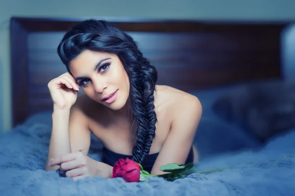 Piękna młoda kobieta z Narwiańskim leżąc na łóżku — Zdjęcie stockowe