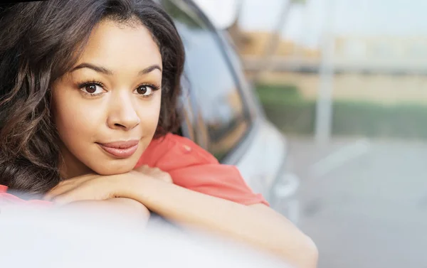 Hübsche junge Frau lehnt sich aus dem Autofenster — Stockfoto