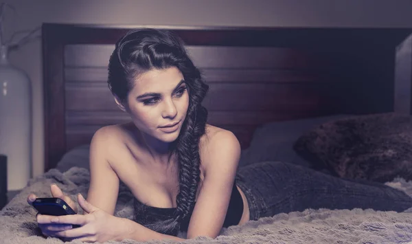 Schöne junge Frau mit geflochtenen Haaren auf dem Bett — Stockfoto