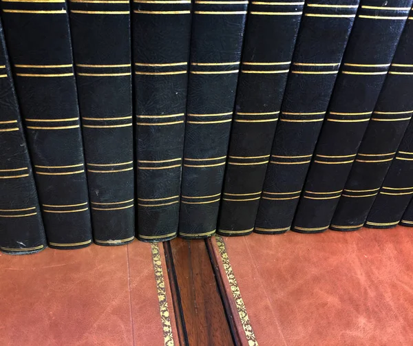 Row of old antique books on vintage desk — Stock Photo, Image