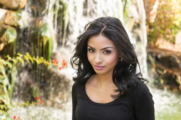 Mooie vrouw buiten door waterfall in mooie natuurlijke omgeving — Stockfoto