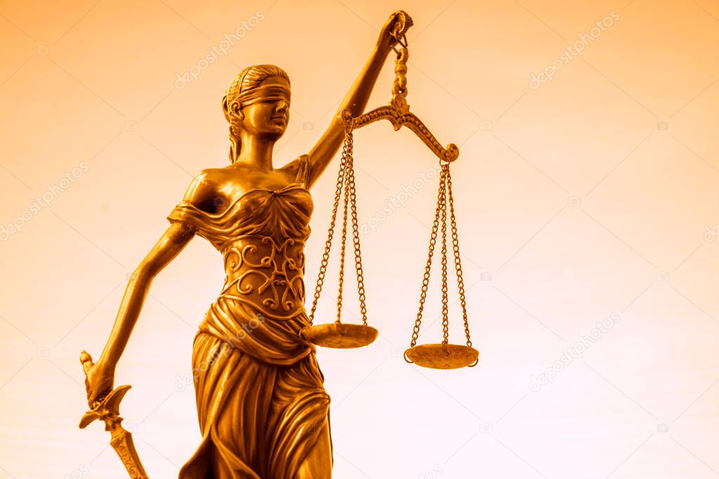 Legal law concept image.  Scales of Justice lit golden light
