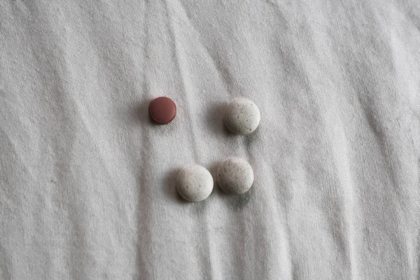 Beige Und Rote Pillen Auf Weißem Tuch — Stockfoto