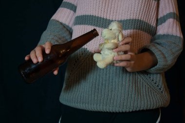 Children's alcoholism. Teen girl with a beer bottle in her hands get toy sheep drunk clipart