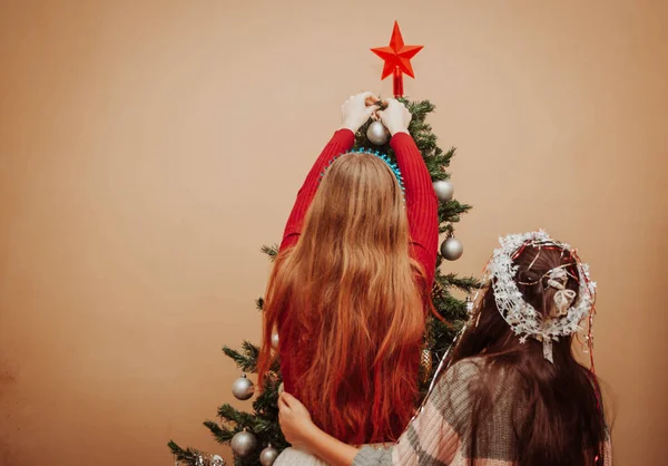 Две девушки украшают елку — стоковое фото