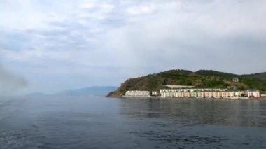 Alushta Bölgesi, Kırım - 15 Ağustos 2019: Bulutlu bir yaz gününde Kırım Yarımadası 'ndan geçen bir gemiden ve Sudak yakınlarındaki bir kasabadan görüntü