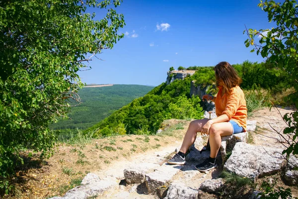 Meisje zit op de top van de berg op zonnige zomerdag — Stockfoto