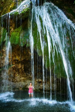 Alushta bölgesi, Kırım - 12 Ağustos 2019: Kırım 'ın en büyük şelalesi olan Cur-Cur şelalesinin suları altında duran kız.