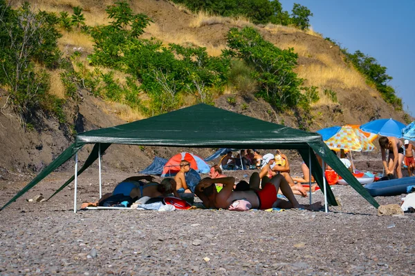 アルシュタ クリミア 2019 テントの下の人々は晴れた夏の日に黒海のビーチでリラックスします — ストック写真