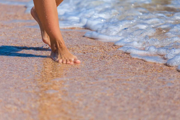 Closeup woman legs on a sea beach — Stock Photo, Image