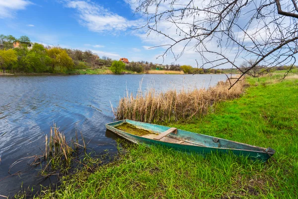 Piccola barca vicino a una costa fluviale — Foto Stock