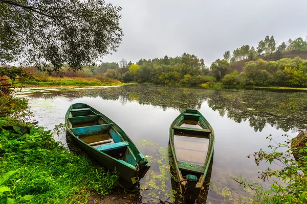 Pequenos barcos de pesca em um rio nebuloso tranquila — Fotografia de Stock
