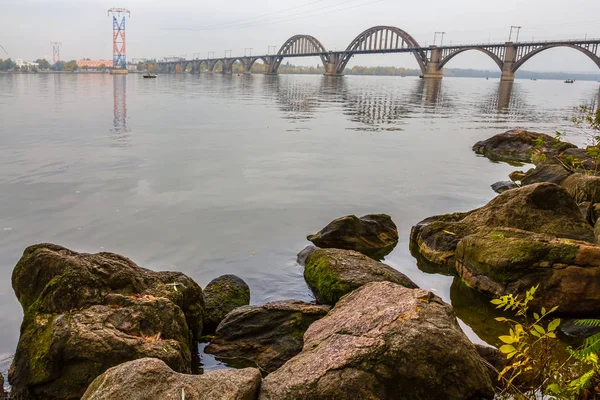 Ponte sobre um rio no tempo molhado escuro — Fotografia de Stock
