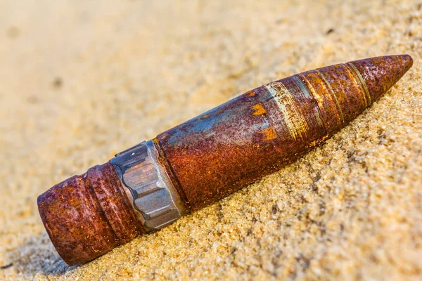 Vieille balle rouillée mensonge sur un fond de sable — Photo