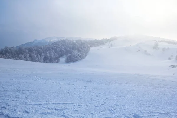 Заснеженные зимние холмы пейзаж в тумане — стоковое фото